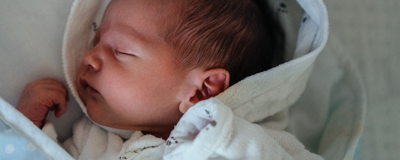 A sleeping baby cradled in soft fabric