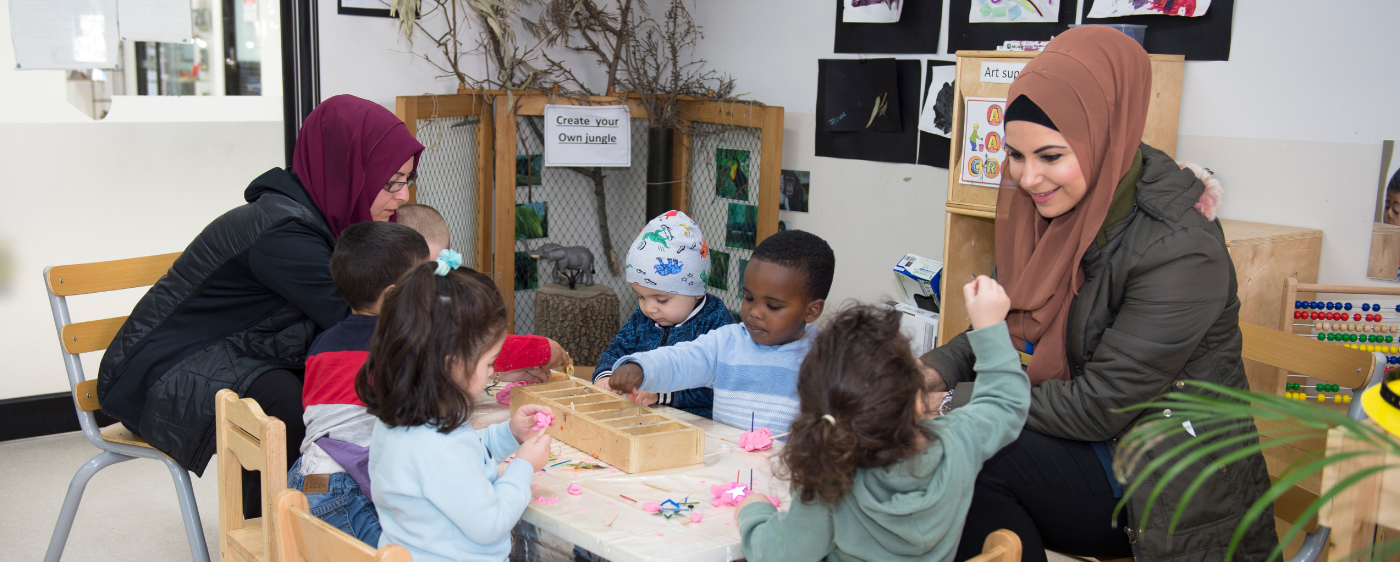 Children engaged in creative play in the Pre-Kinder Room