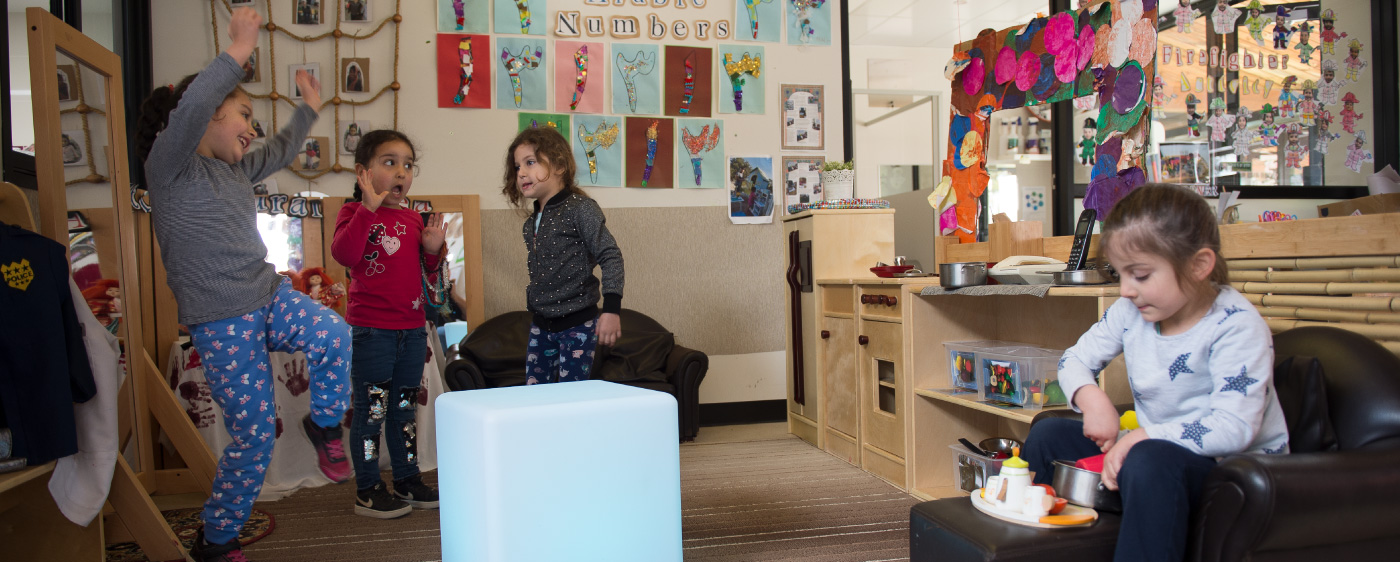 A toddler exploring with educators in the Lilly Pilly Room